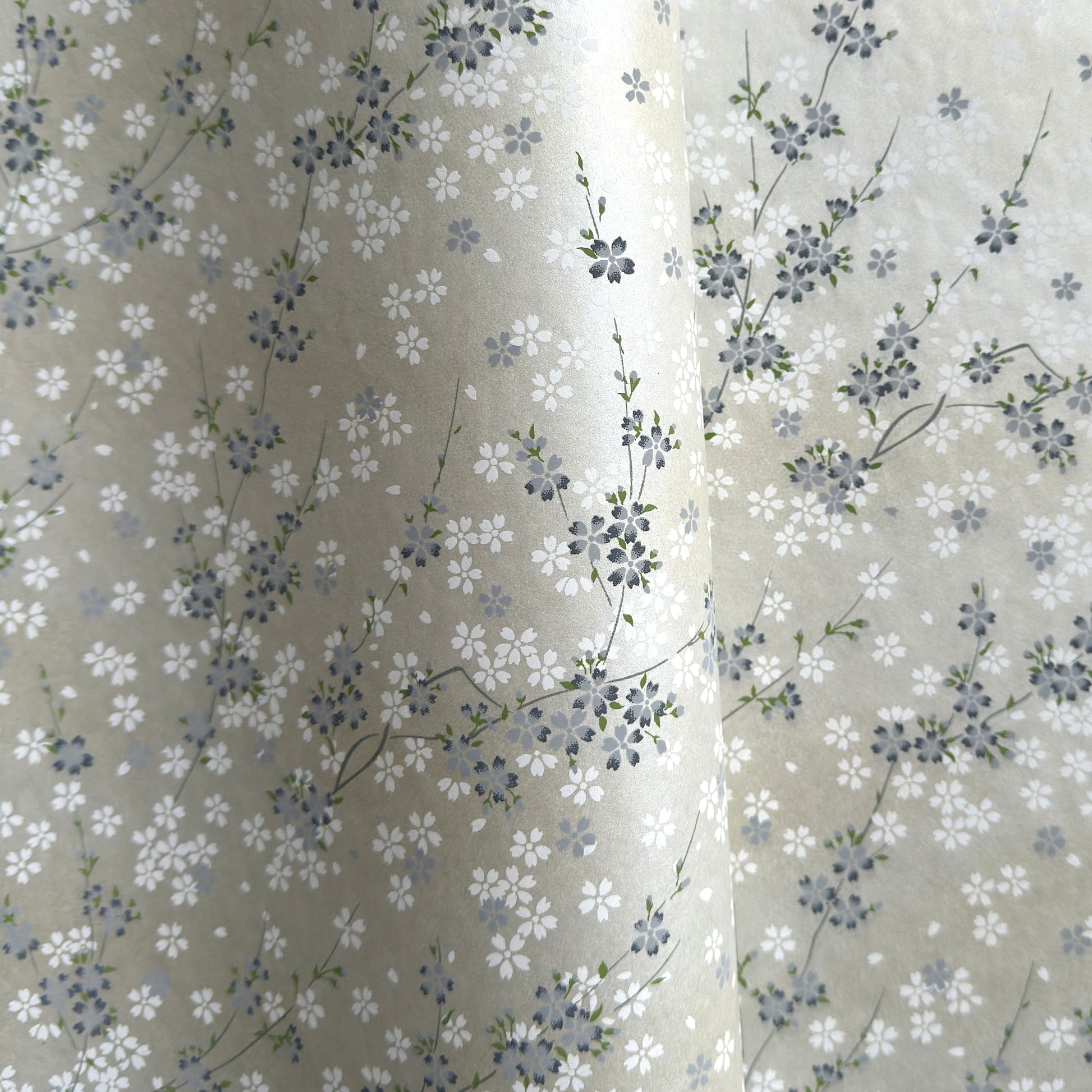Japanese silkscreen chiyogami paper with a delicate flower design in soft grey on an ivory pearlescent backdrop