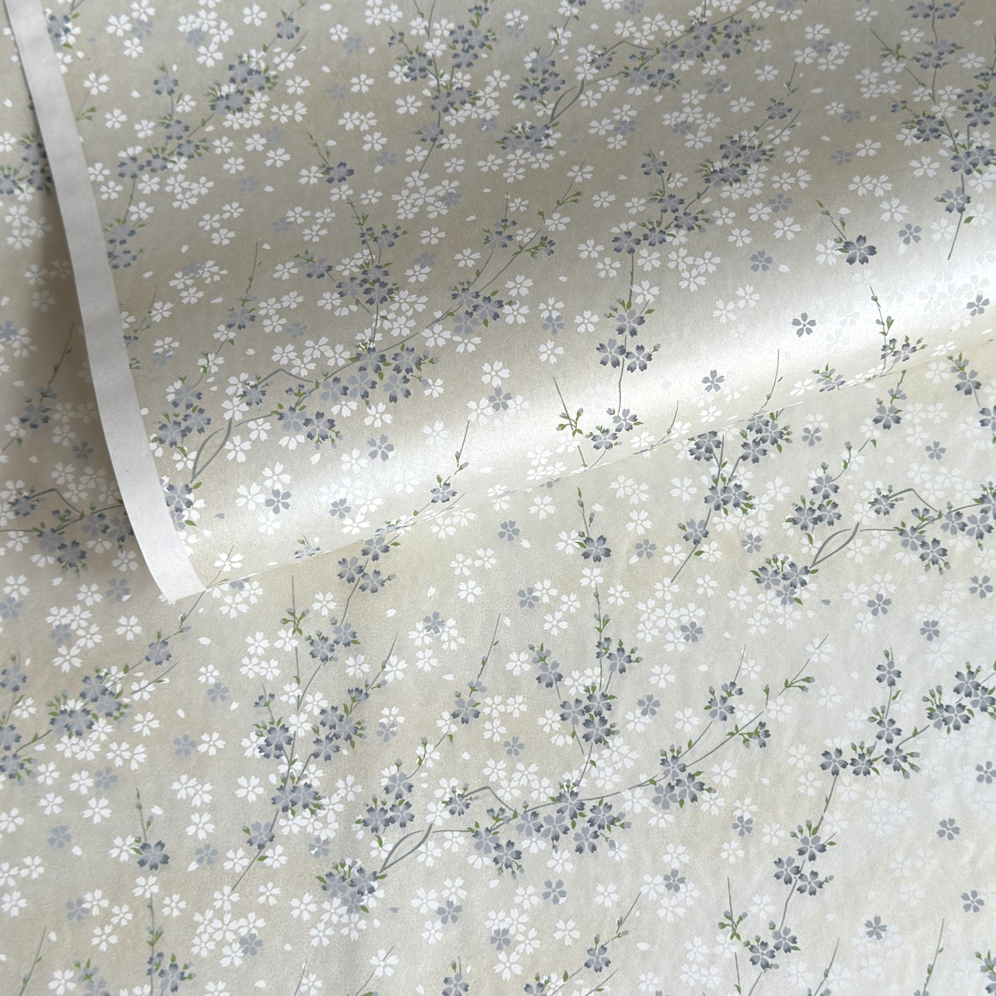 Japanese silkscreen chiyogami paper with a delicate flower design in soft grey on an ivory pearlescent backdrop