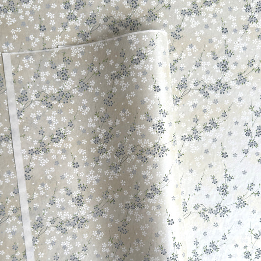 Japanese silkscreen chiyogami paper with a delicate flower design in soft grey on an ivory pearlescent backdrop