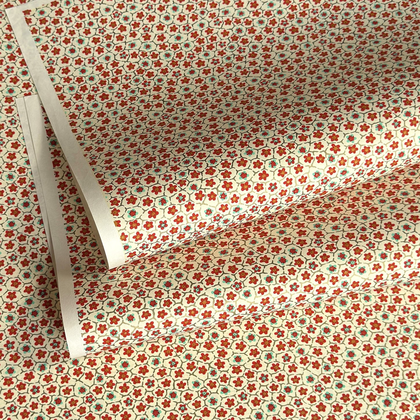 japanese silk-screen handmade paper, chiyogami, with red and aqua plum flowers repeat pattern