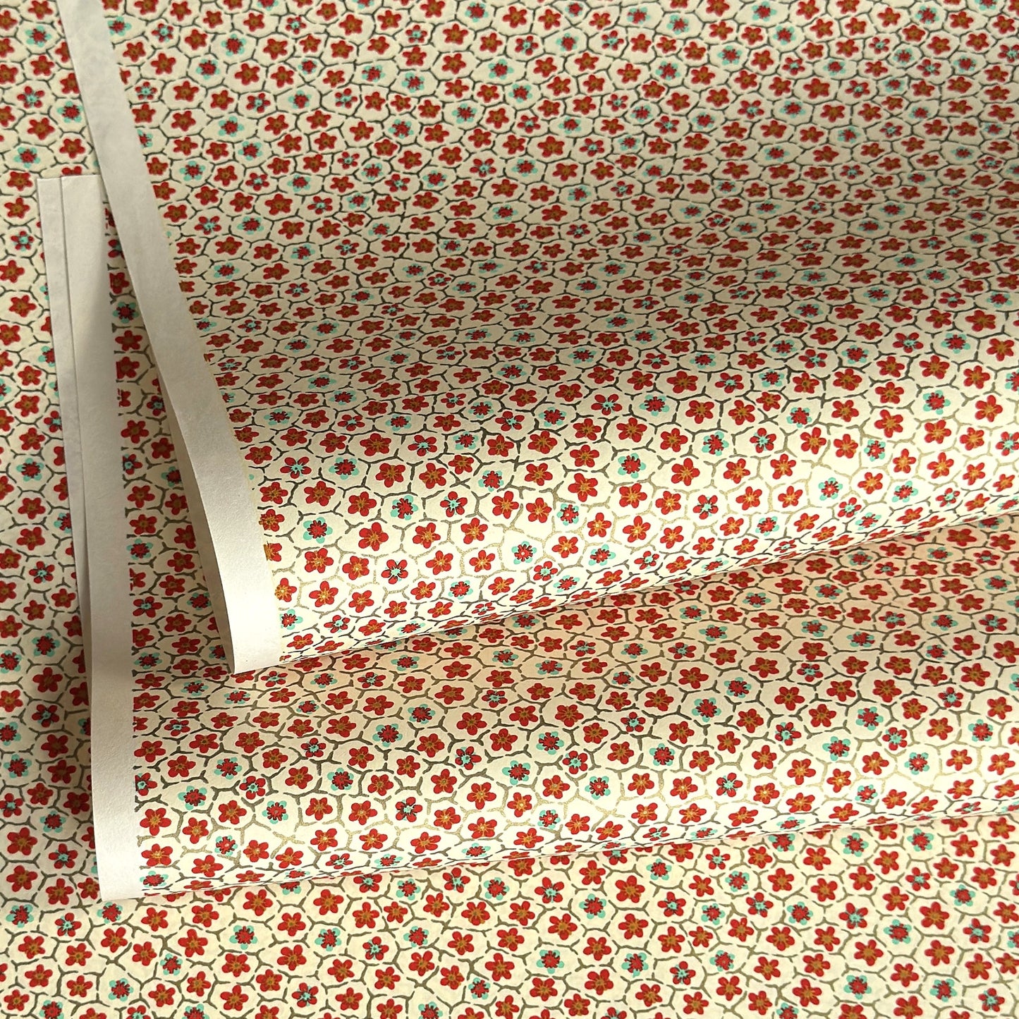 japanese silk-screen handmade paper, chiyogami, with red and aqua plum flowers repeat pattern