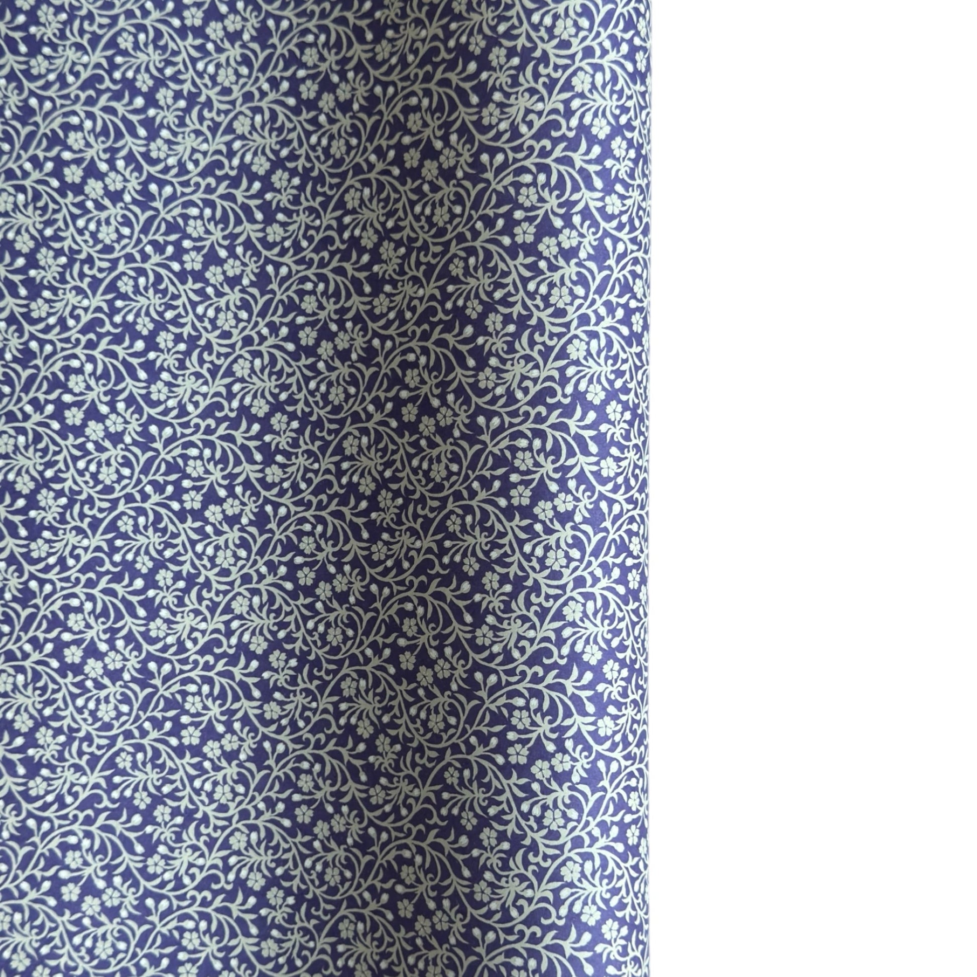 a sheet of Japanese silkscreen printed chiyogami paper with a small floral repeat pattern in grey and white on a periwinkle blue background