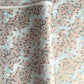 Japanese silkscreen chiyogami paper with an abundance of pale pink cherry blossom with a pale blue backdrop of meandering water, finished with metallic gold ink.