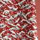Japanese silkscreen chiyogami paper with a repeat pattern of white cranes in flight on a red and silver background