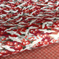 Japanese silkscreen chiyogami paper with a repeat pattern of white cranes in flight on a red and silver background