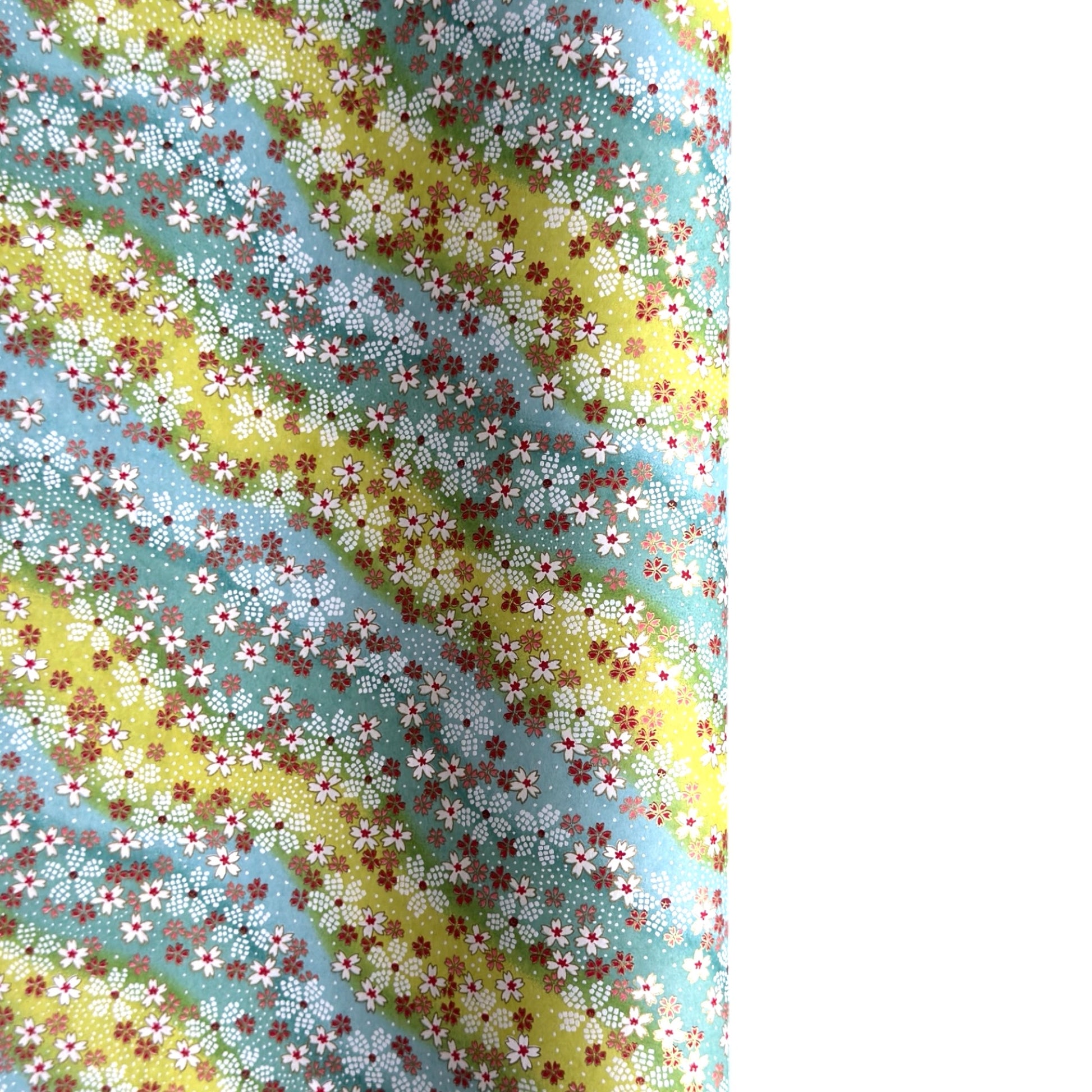 Japanese chiyogami paper silkscreened with a dainty pattern of white sakura flowers on an backdrop of aqua and lime diagonal wavy stripes