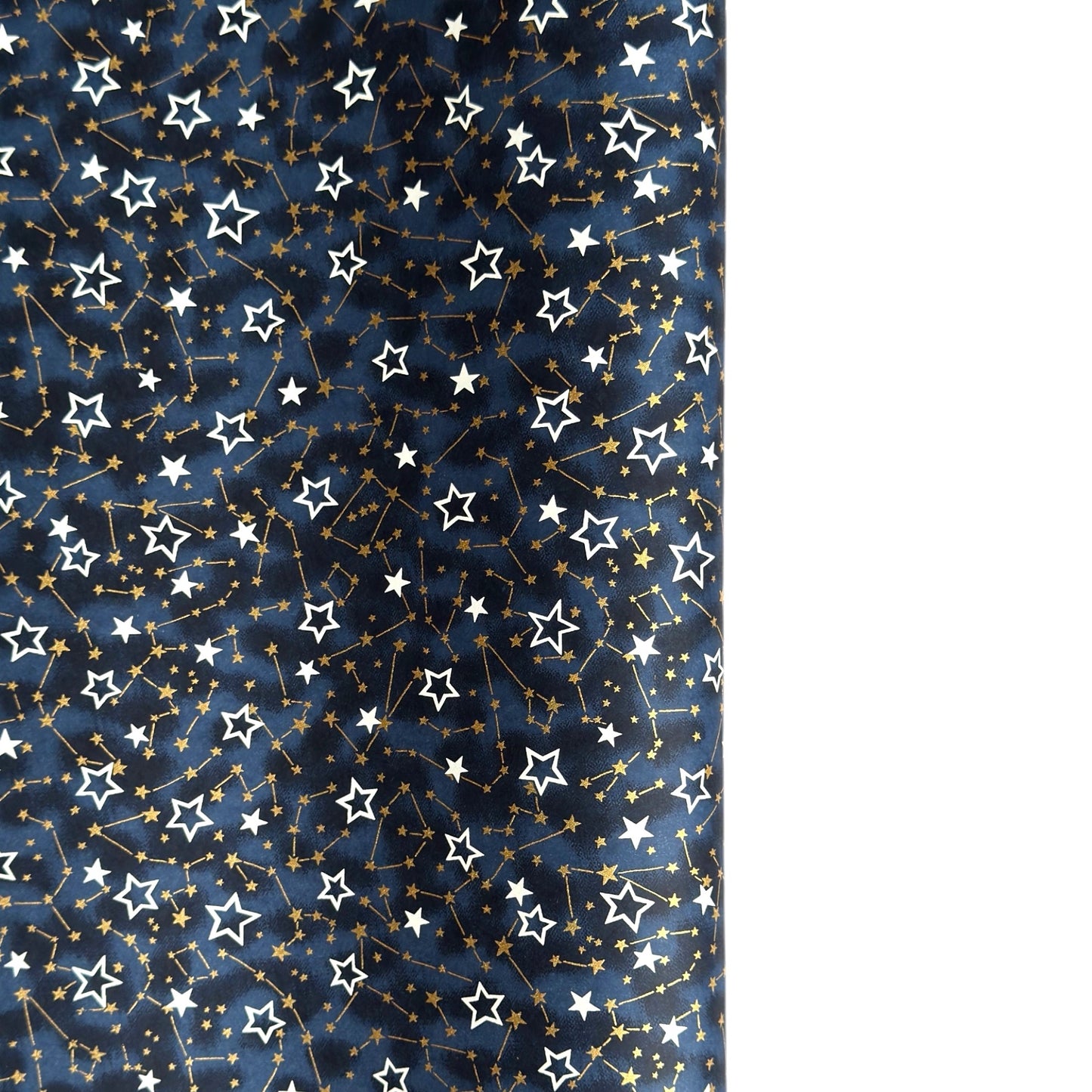 a sheet of Japanese chiyogami yuzen paper with a pattern of white and gold stars on a midnight blue background