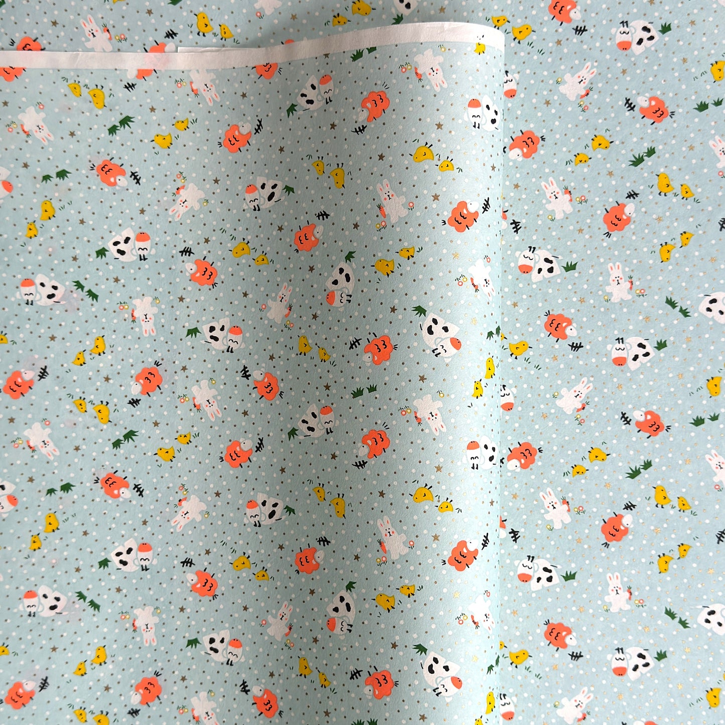 japanese silk-screen handmade paper showing spring animals motifs on a light blue backdrop