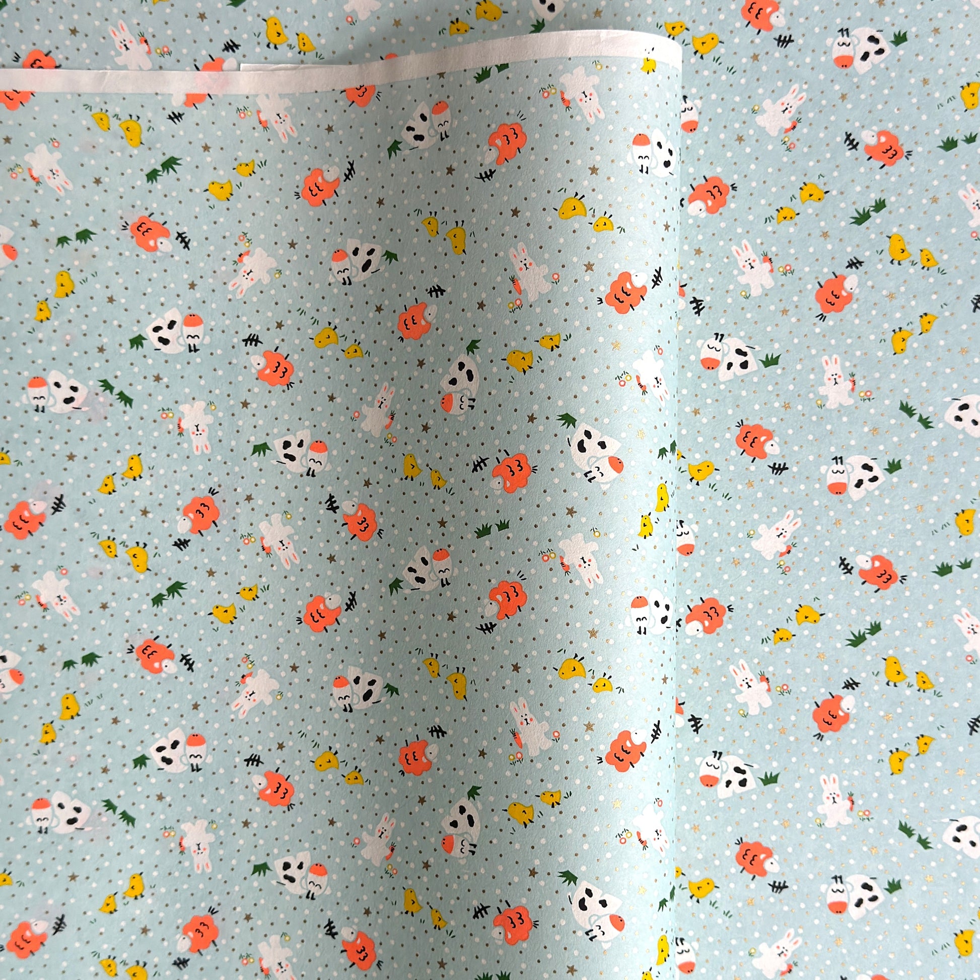 japanese silk-screen handmade paper showing spring animals motifs on a light blue backdrop