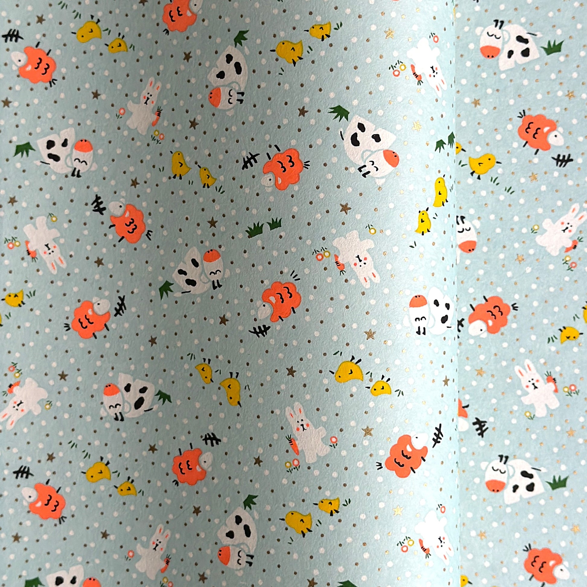 japanese silk-screen handmade paper showing spring animals motifs on a light blue backdrop