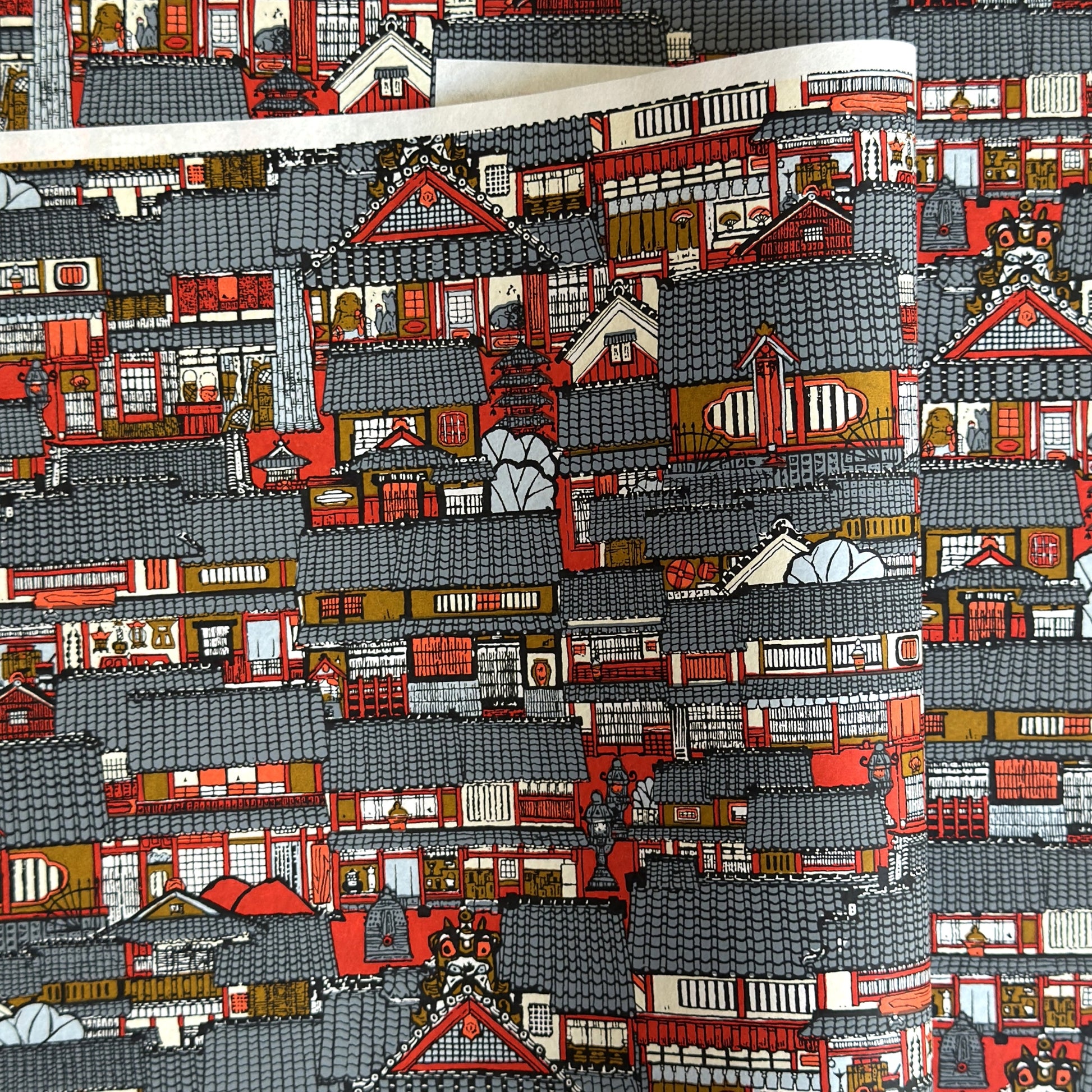 Japanese chiyogami paper (silkscreen printed) with a city landscape in grey, red and orange.