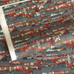 Japanese chiyogami paper (silkscreen printed) with a city landscape in grey, red and orange.