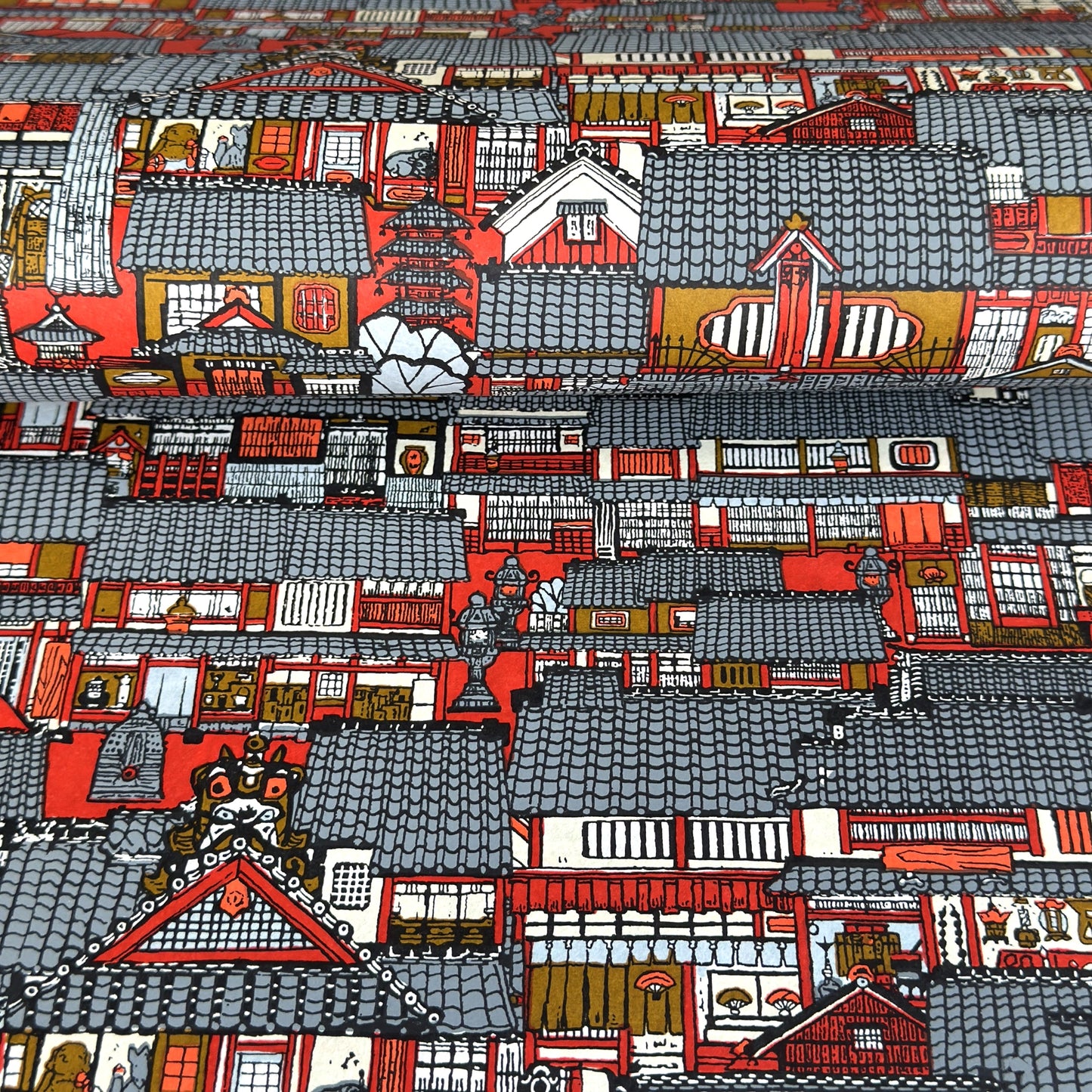 Japanese chiyogami paper (silkscreen printed) with a city landscape in grey, red and orange.