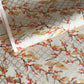 japanese silk-screen handmade paper, chiyogami, showing branches of red cherry blossom and gold clouds on a backdrop of silver, cream and gold
