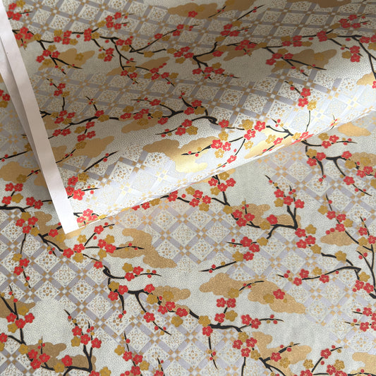 japanese silk-screen handmade paper, chiyogami, showing branches of red cherry blossom and gold clouds on a backdrop of silver, cream and gold