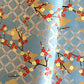 japanese silk-screen handmade paper showing branches of red blossom, gold clouds on a teal, gold and silver geometric backdrop.