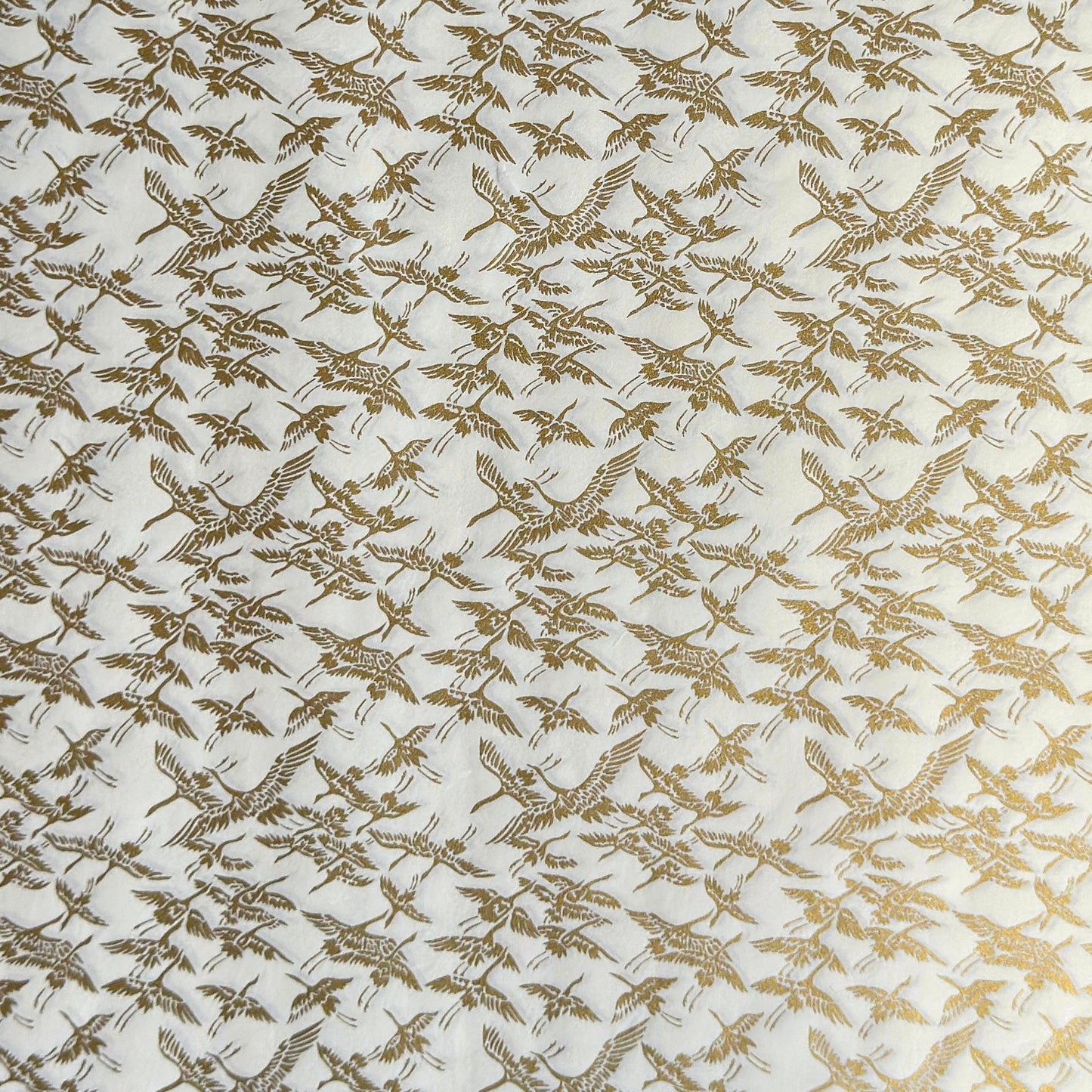 japanese silk-screen handmade paper showing gold cranes in flight on ivory backdrop
