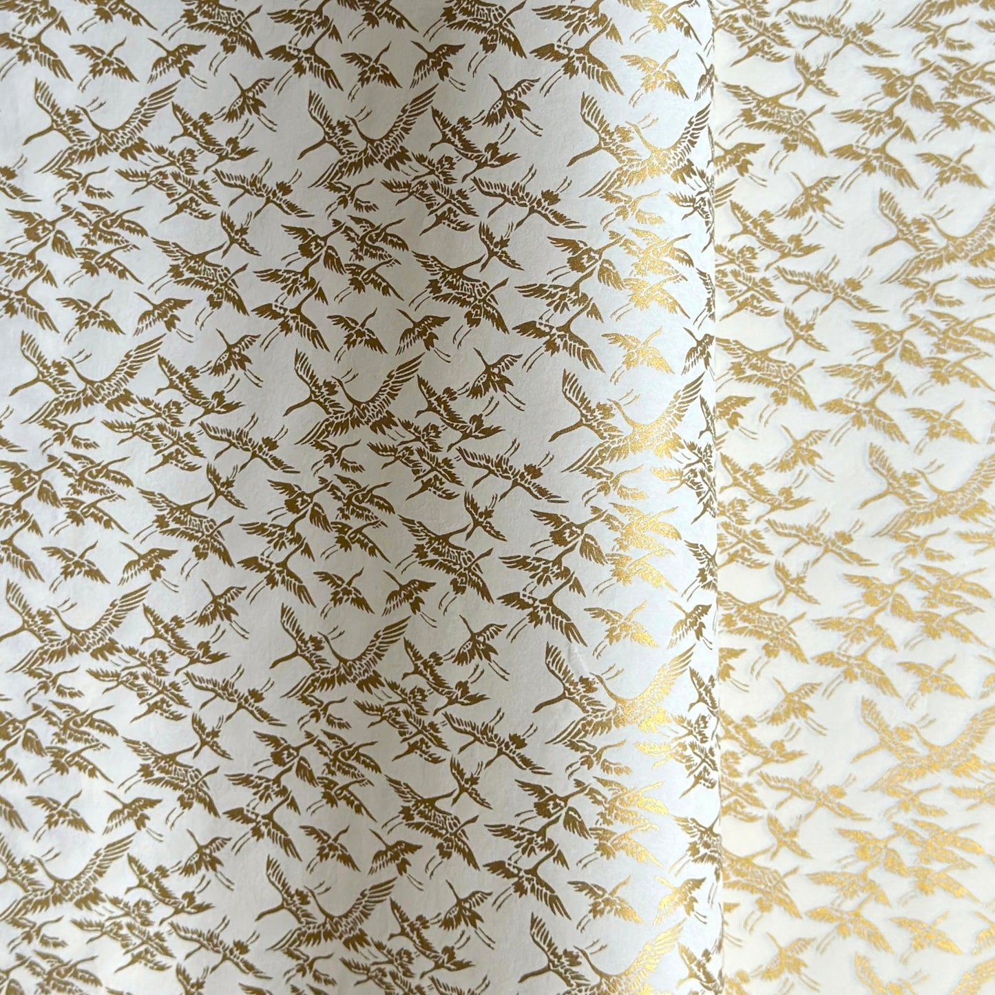 japanese silk-screen handmade paper showing gold cranes in flight on ivory backdrop