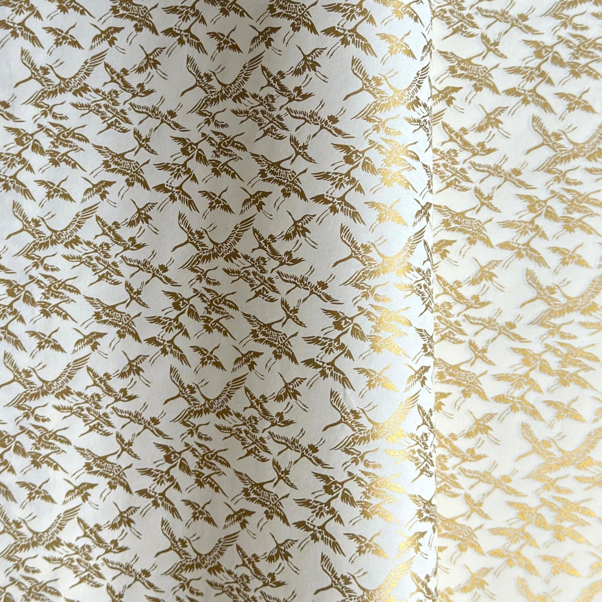 japanese silk-screen handmade paper showing gold cranes in flight on ivory backdrop