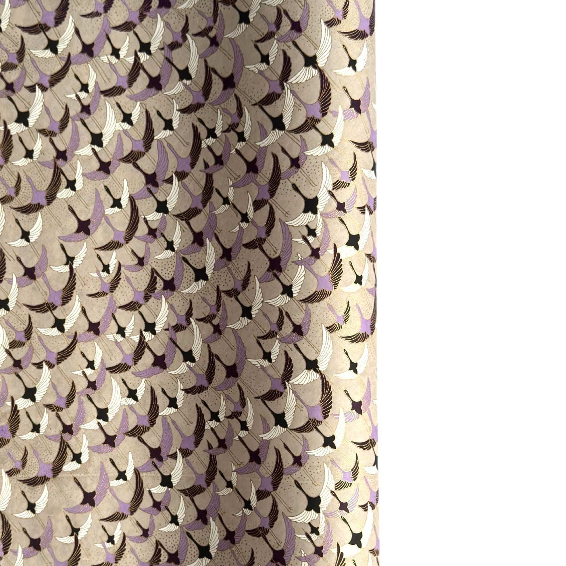 a sheet of Japanese chiyogami yuzen paper with a pattern of cranes in flight in lilac, black, taupe and gold