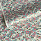Japanese chiyogami paper with a pattern of white cranes, pink cherry blossom on a blue background. 