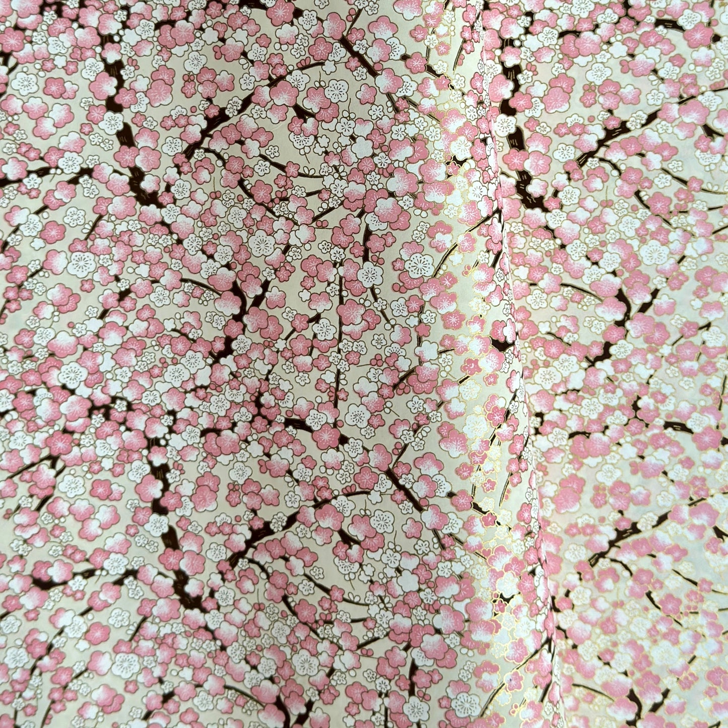 Japanese chiyogami paper with pale pink plum blossom, dark brown branches on an ivory background.