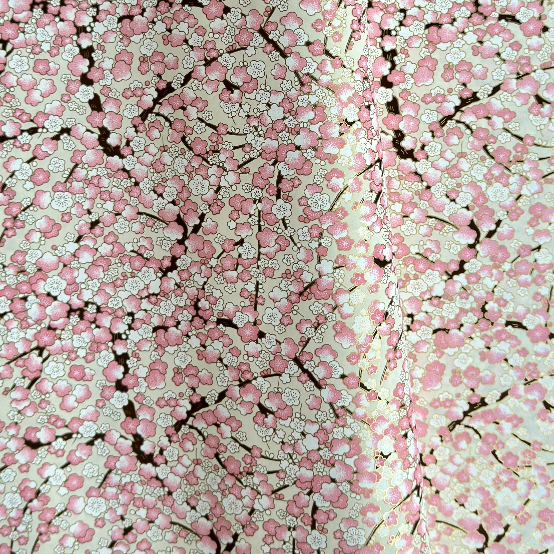 Japanese chiyogami paper with pale pink plum blossom, dark brown branches on an ivory background.