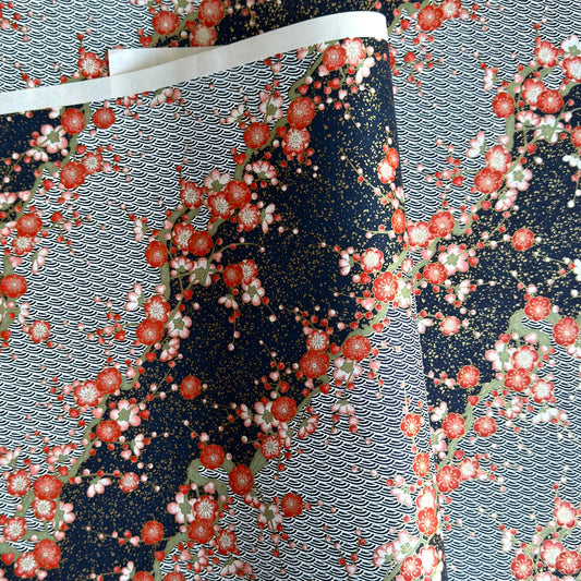 Diagonal branches of rich pink plum (ume) blossom on a midnight blue background with gold accents. Japanese chiyogami paper
