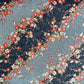 Diagonal branches of rich pink plum (ume) blossom on a midnight blue background with gold accents. Japanese chiyogami paper