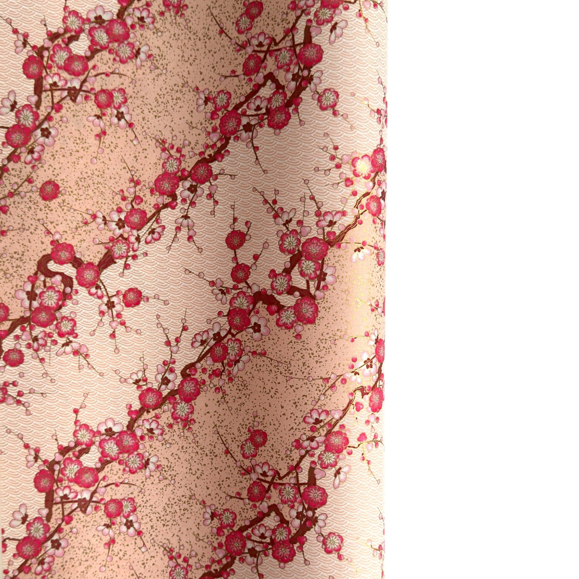 Diagonal branches of pink plum (ume) blossom on a light pink background with gold accents. Japanese chiyogami paper