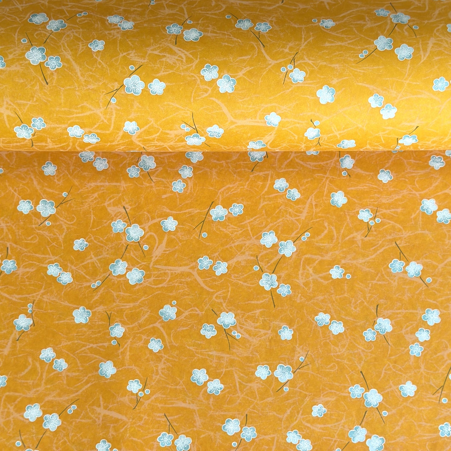 Pale blue plum (ume) blossom with a rich saffron backdrop.  Japanese chiyogami paper.