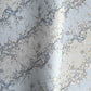Japanese chiyogami paper with diagonal branches of sky blue plum blossom on a light blue background. 