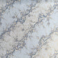 Japanese chiyogami paper with diagonal branches of sky blue plum blossom on a light blue background. 