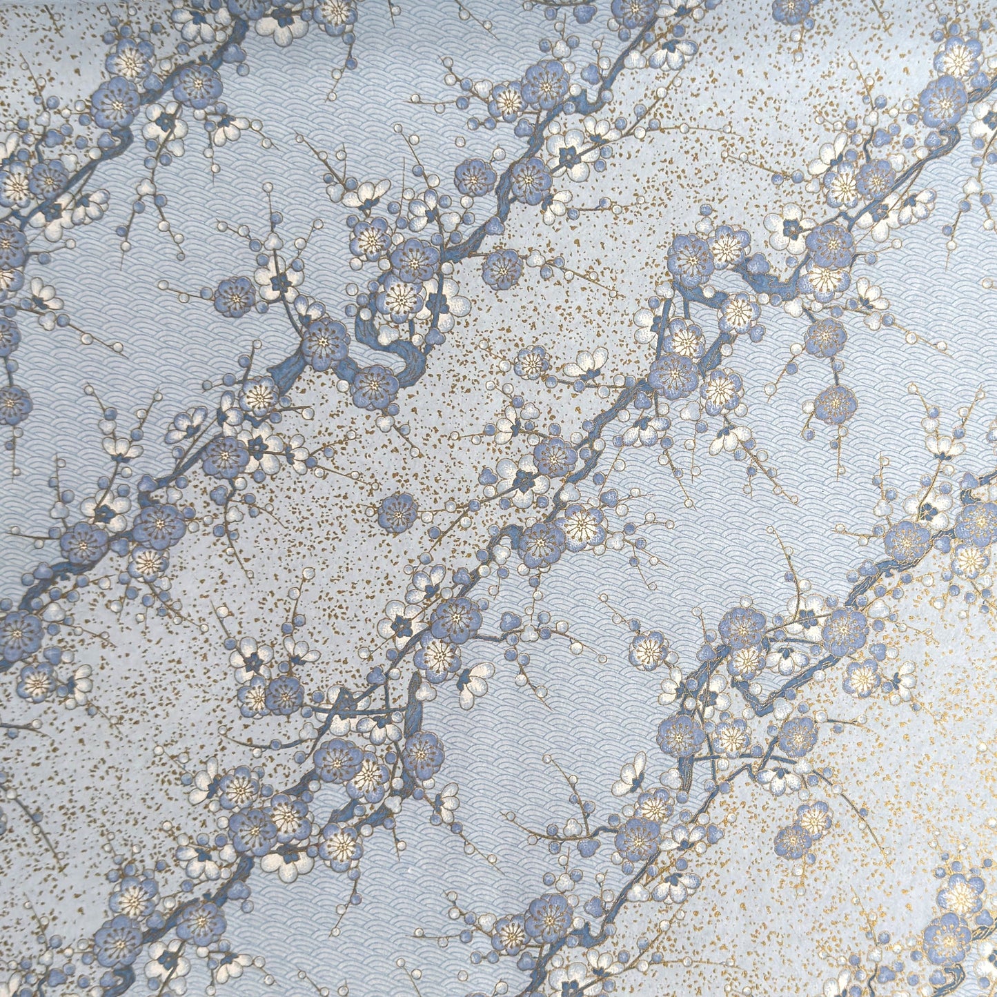 Japanese chiyogami paper with diagonal branches of sky blue plum blossom on a light blue background. 