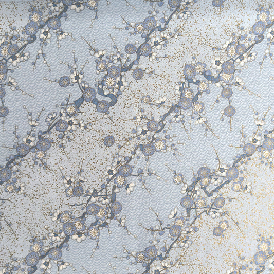 Japanese chiyogami paper with diagonal branches of sky blue plum blossom on a light blue background. 