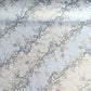 Japanese chiyogami paper with diagonal branches of sky blue plum blossom on a light blue background. 