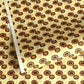 Japanese silkscreen chiyogami paper with a brown and orange umbrella pattern on a buttermilk backdrop 