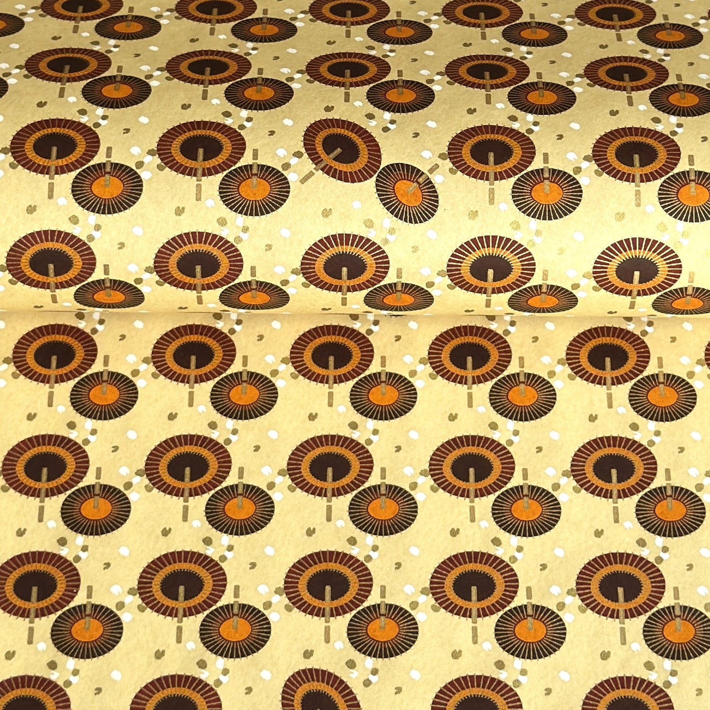Japanese silkscreen chiyogami paper with a brown and orange umbrella pattern on a buttermilk backdrop 