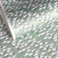 japanese silk-screen handmade paper showing white cranes in flight on a light teal and gold backdrop