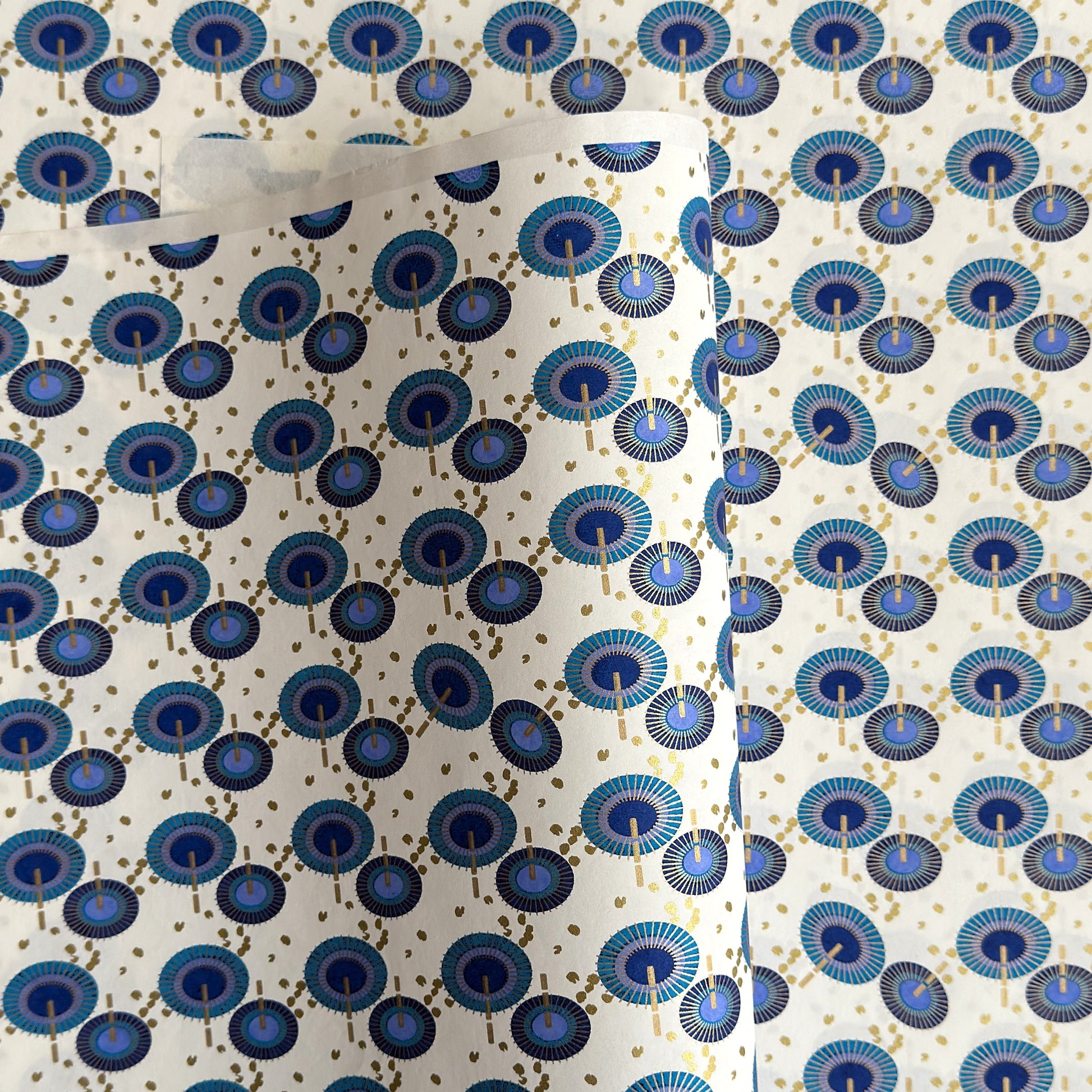 japanese silk-screen handmade paper showing a repeat pattern of blue umbrellas with gold highlights