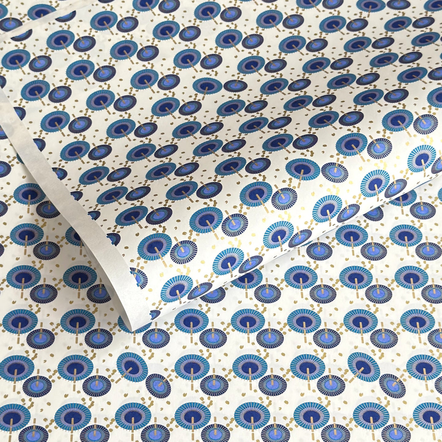 japanese silk-screen handmade paper showing a repeat pattern of blue umbrellas with gold highlights