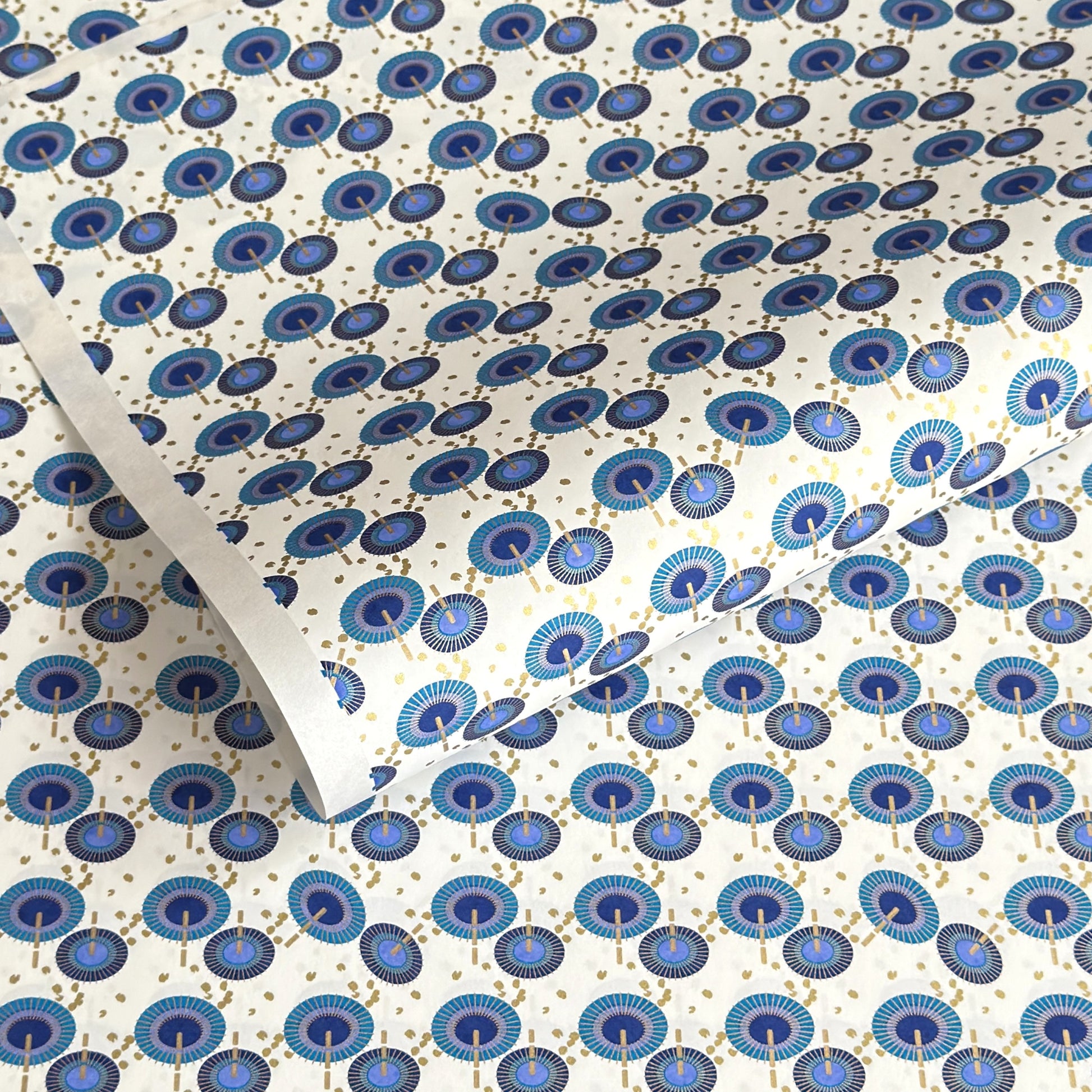 japanese silk-screen handmade paper showing a repeat pattern of blue umbrellas with gold highlights