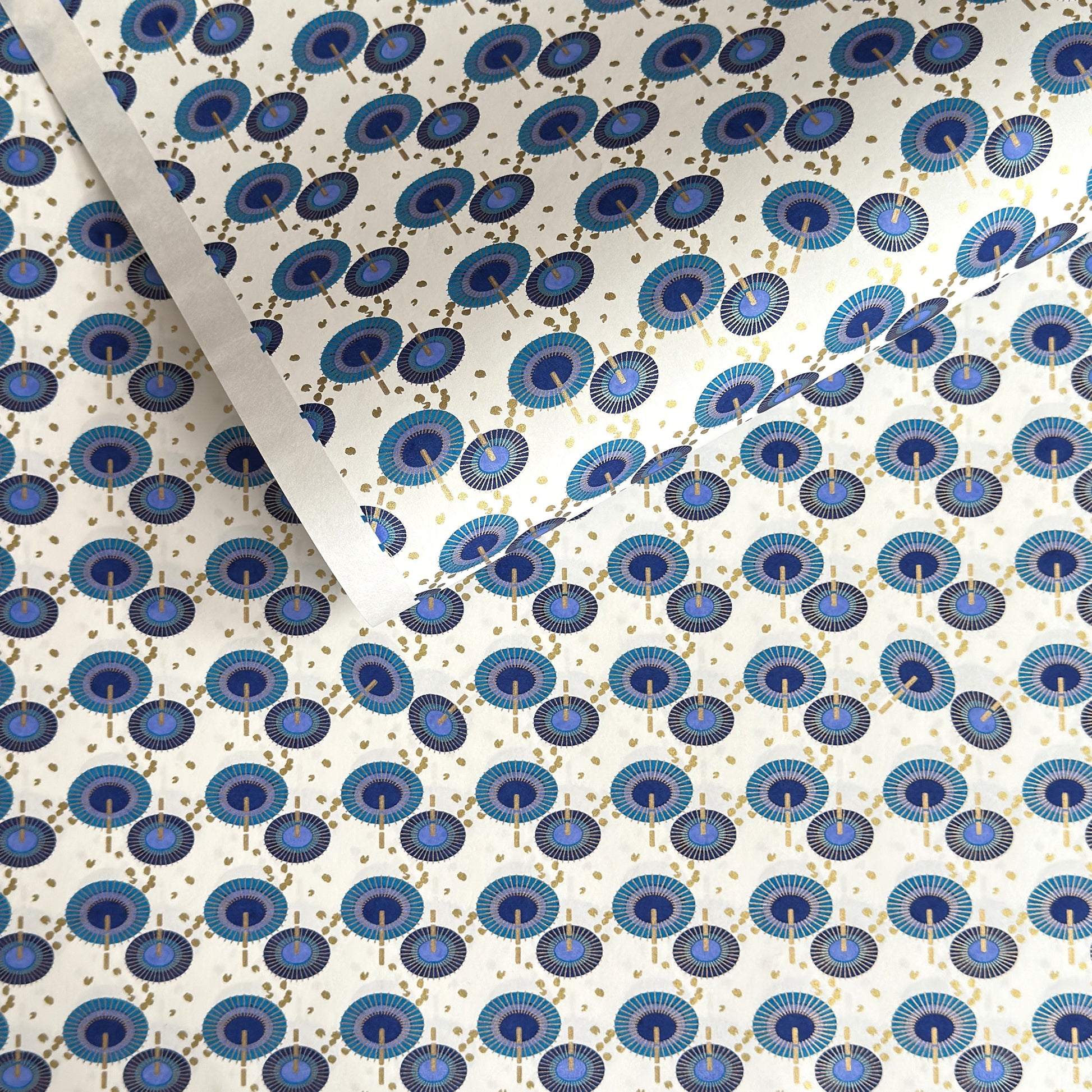 japanese silk-screen handmade paper showing a repeat pattern of blue umbrellas with gold highlights