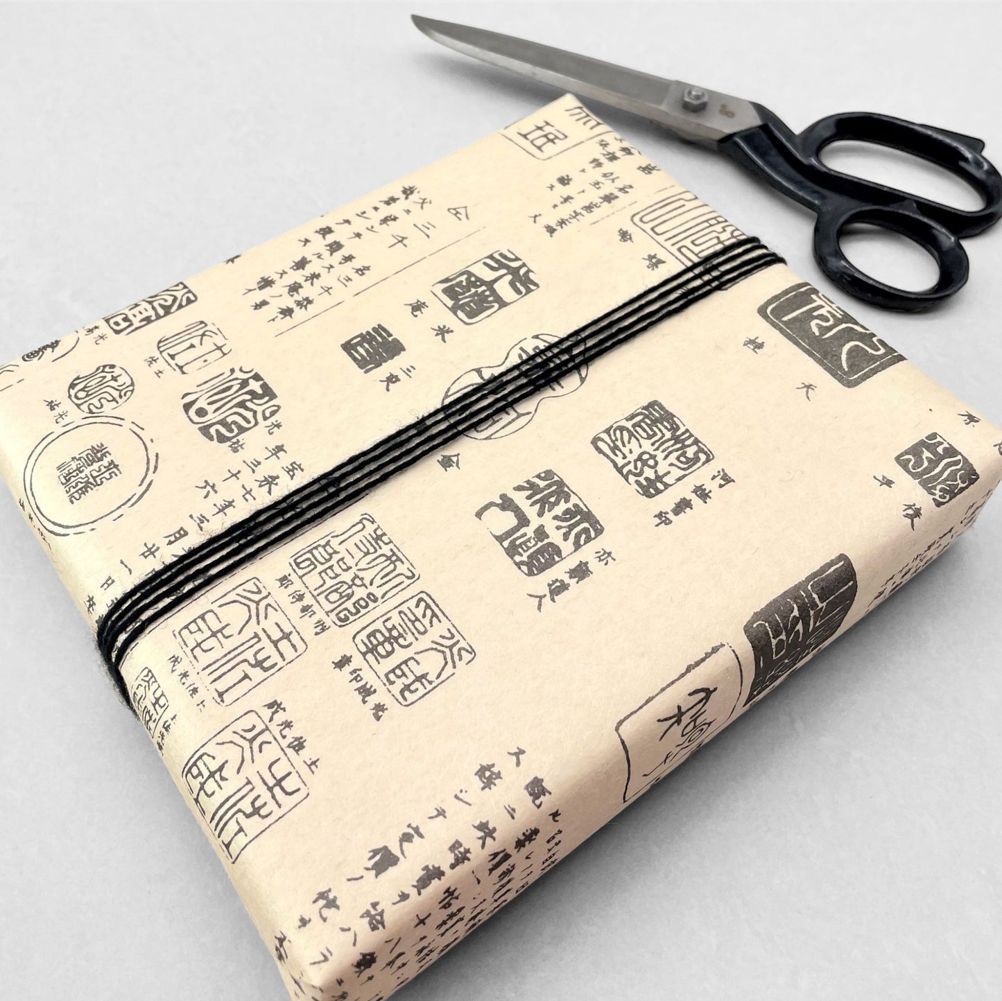 japanese tissue paper with cream backdrop and black Japanese "chops" , signature stamps