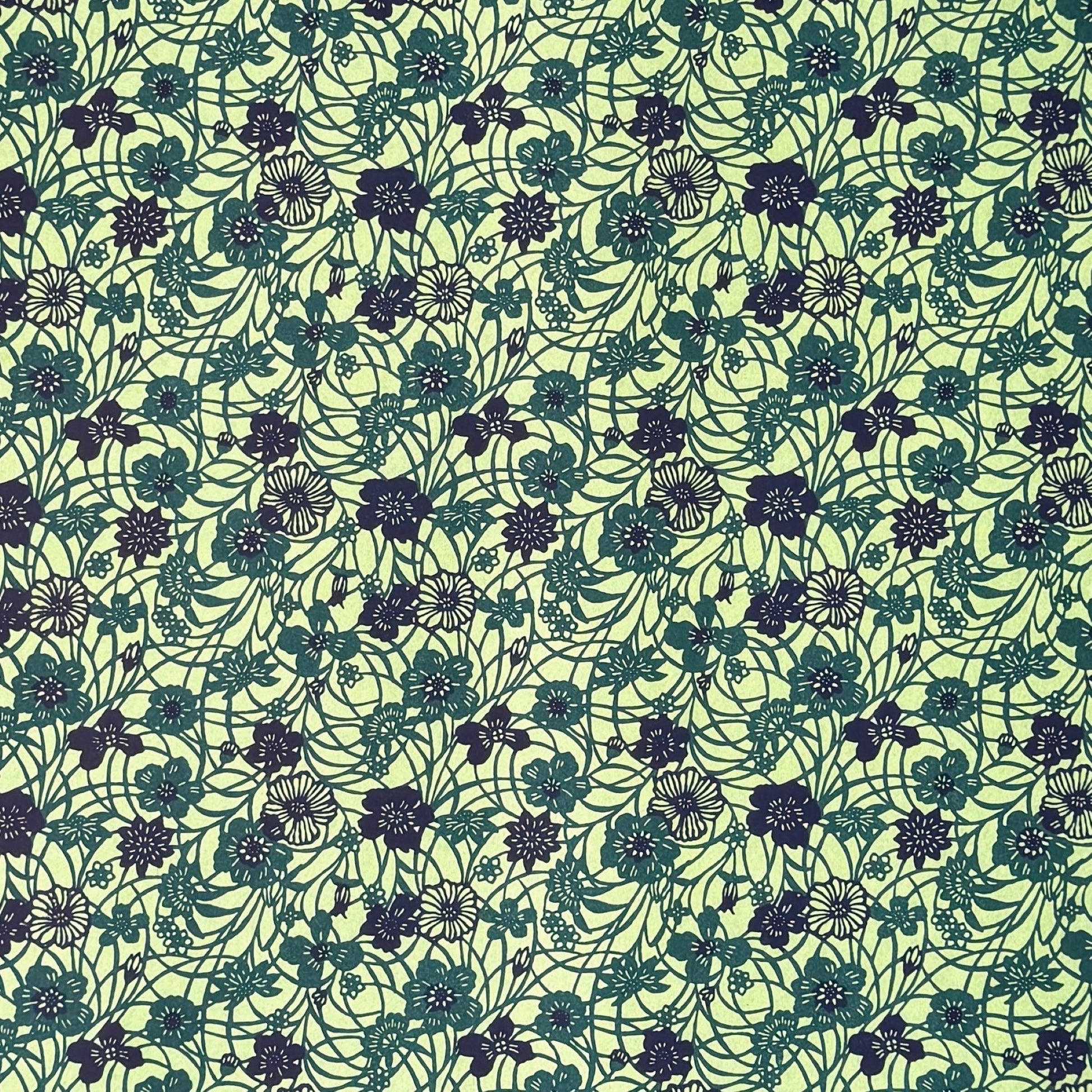 a sheet of katazome paper with a floral design in shades of green and indigo blue.
