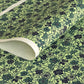 a sheet of katazome paper with a floral design in shades of green and indigo blue.
