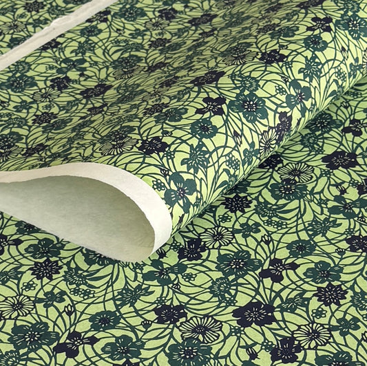 a sheet of katazome paper with a floral design in shades of green and indigo blue.