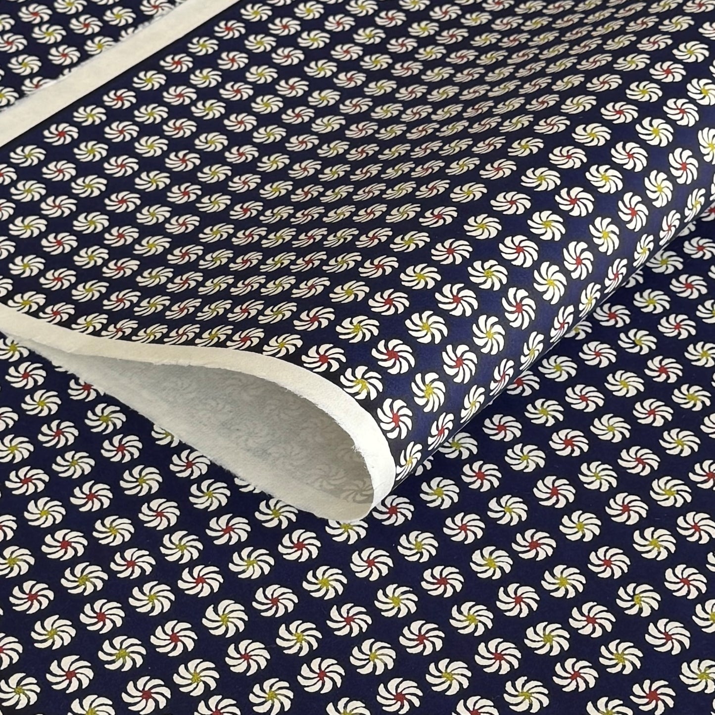 Small pattern with abstract circular flowers in white, red and yellow on a dark blue background. A sheet of katazome paper