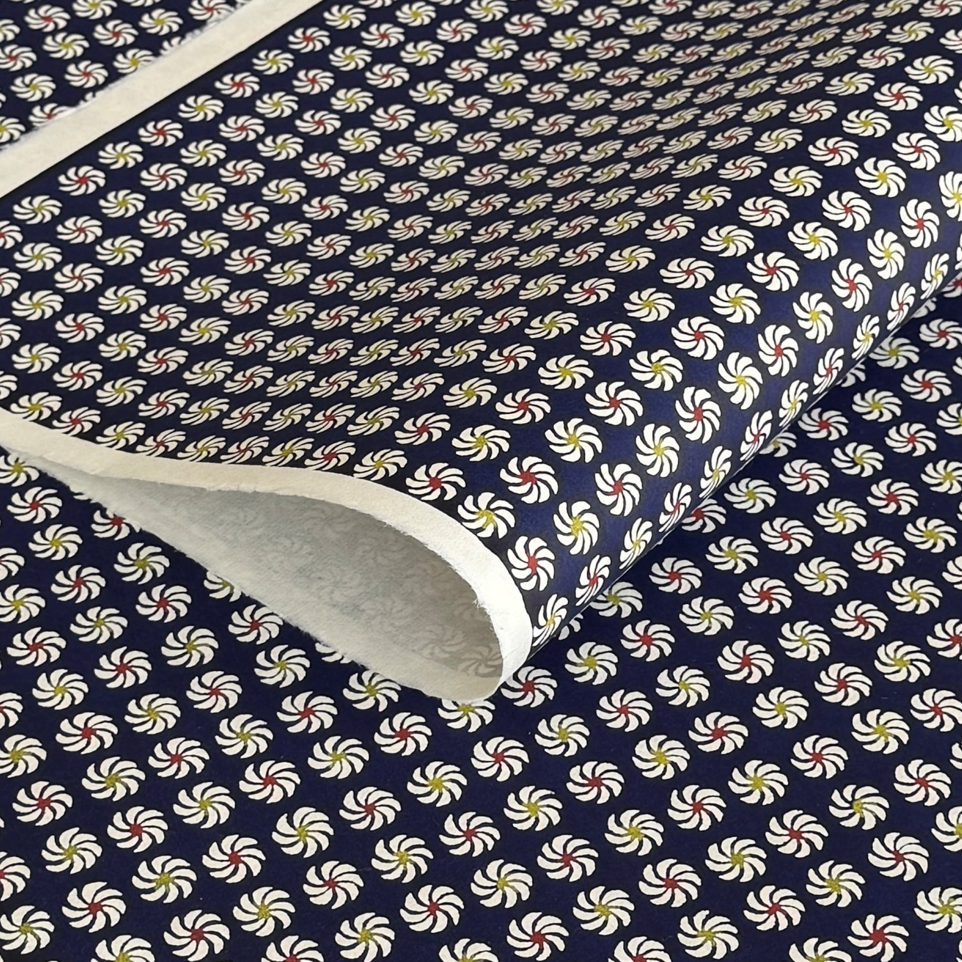 Small pattern with abstract circular flowers in white, red and yellow on a dark blue background. A sheet of katazome paper