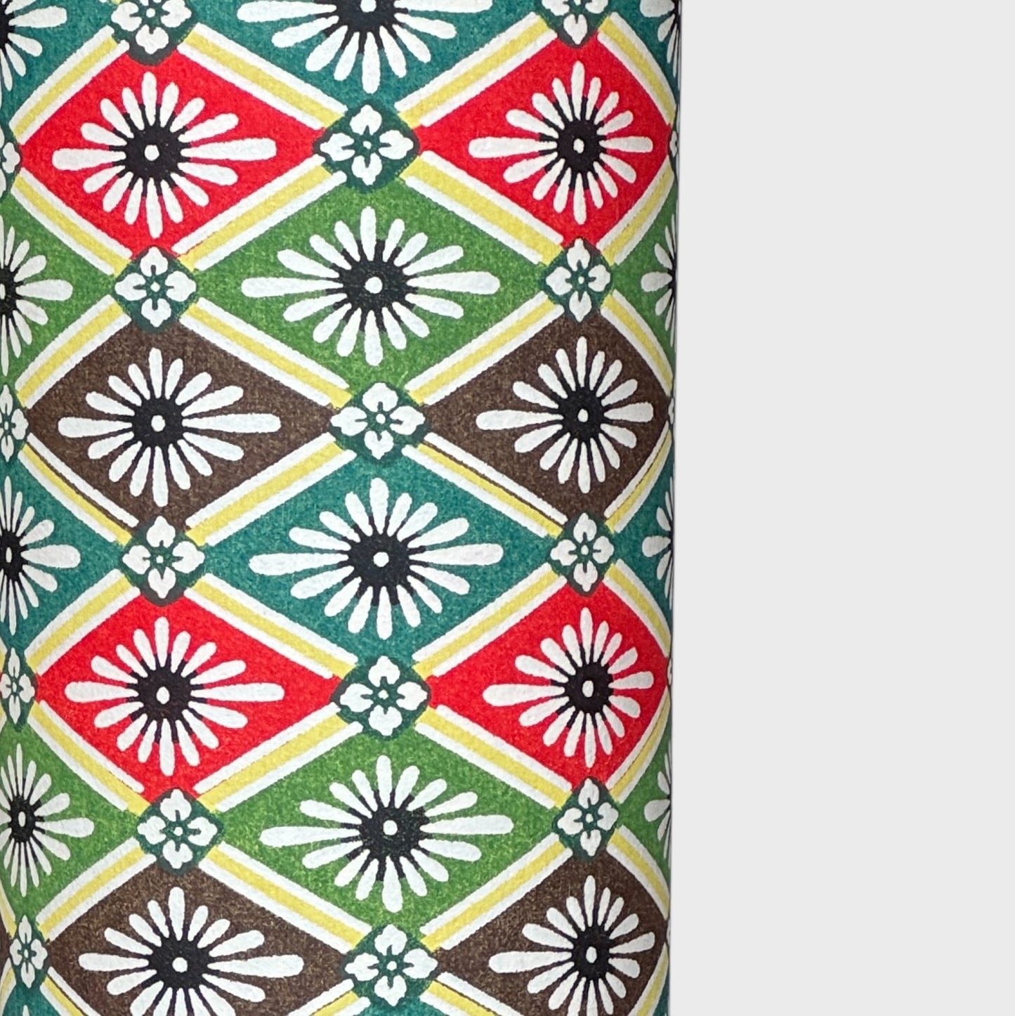 A sheet of katazome paper with a repeat rhombus pattern with the Japanese motif of the water caltrop plant (hishi) depicted alongside the four-petal flower of the water chestnut (hanabishi) in red, green. brown and teal.
